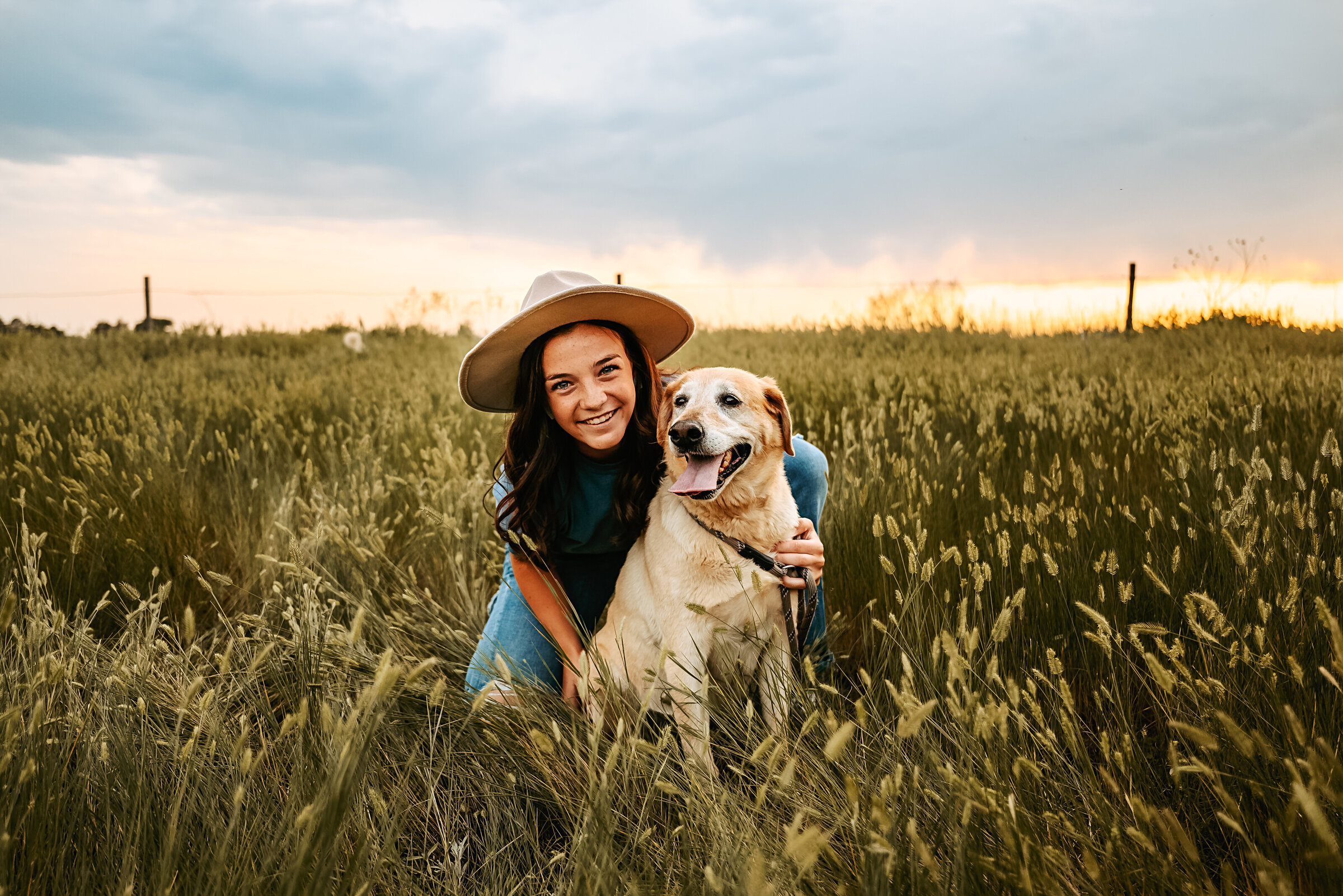 senior girl hugs her dog in a field for Nebraska Senior Photos
