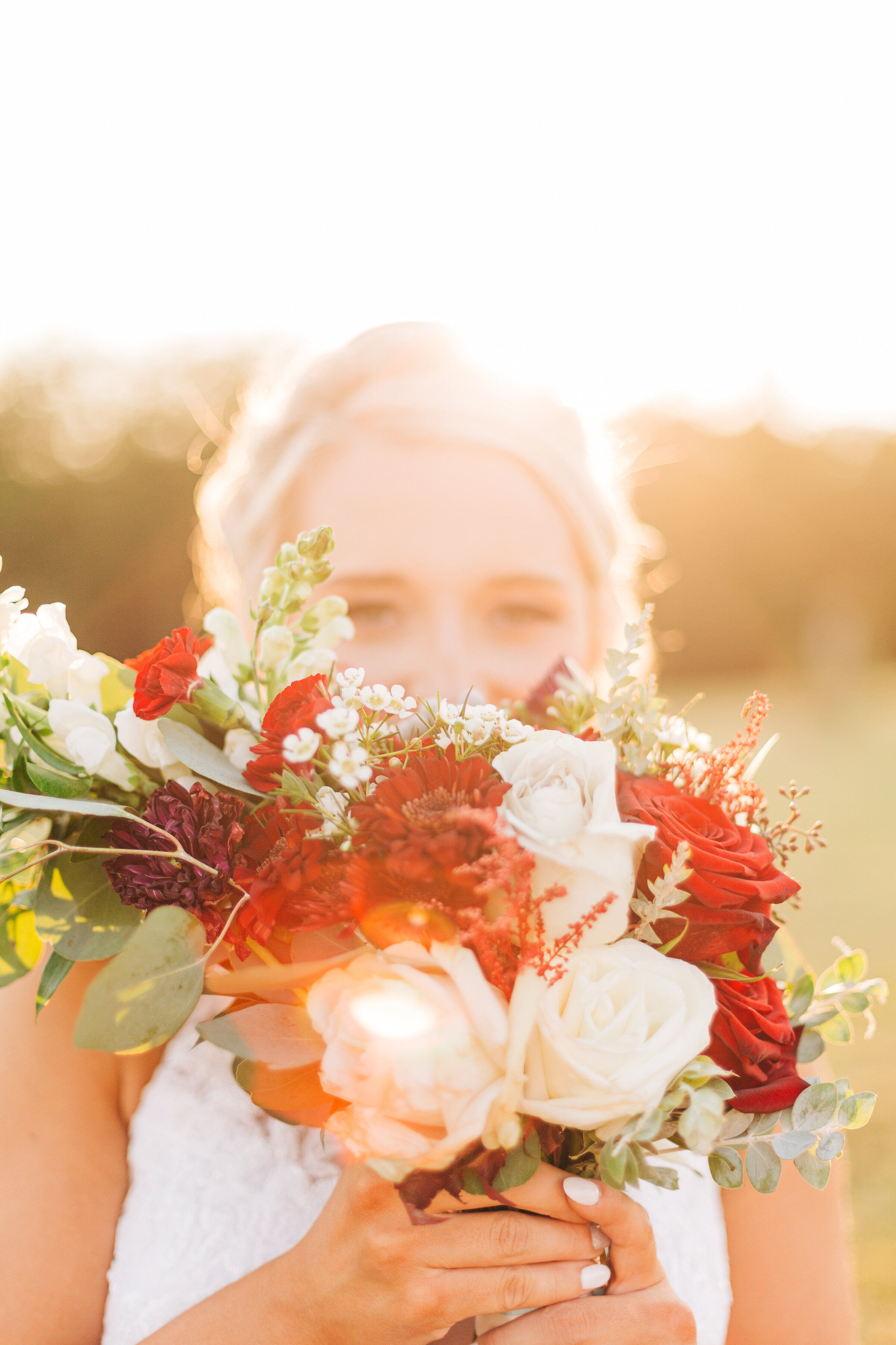 Bride holding her red and cream rose bouquet