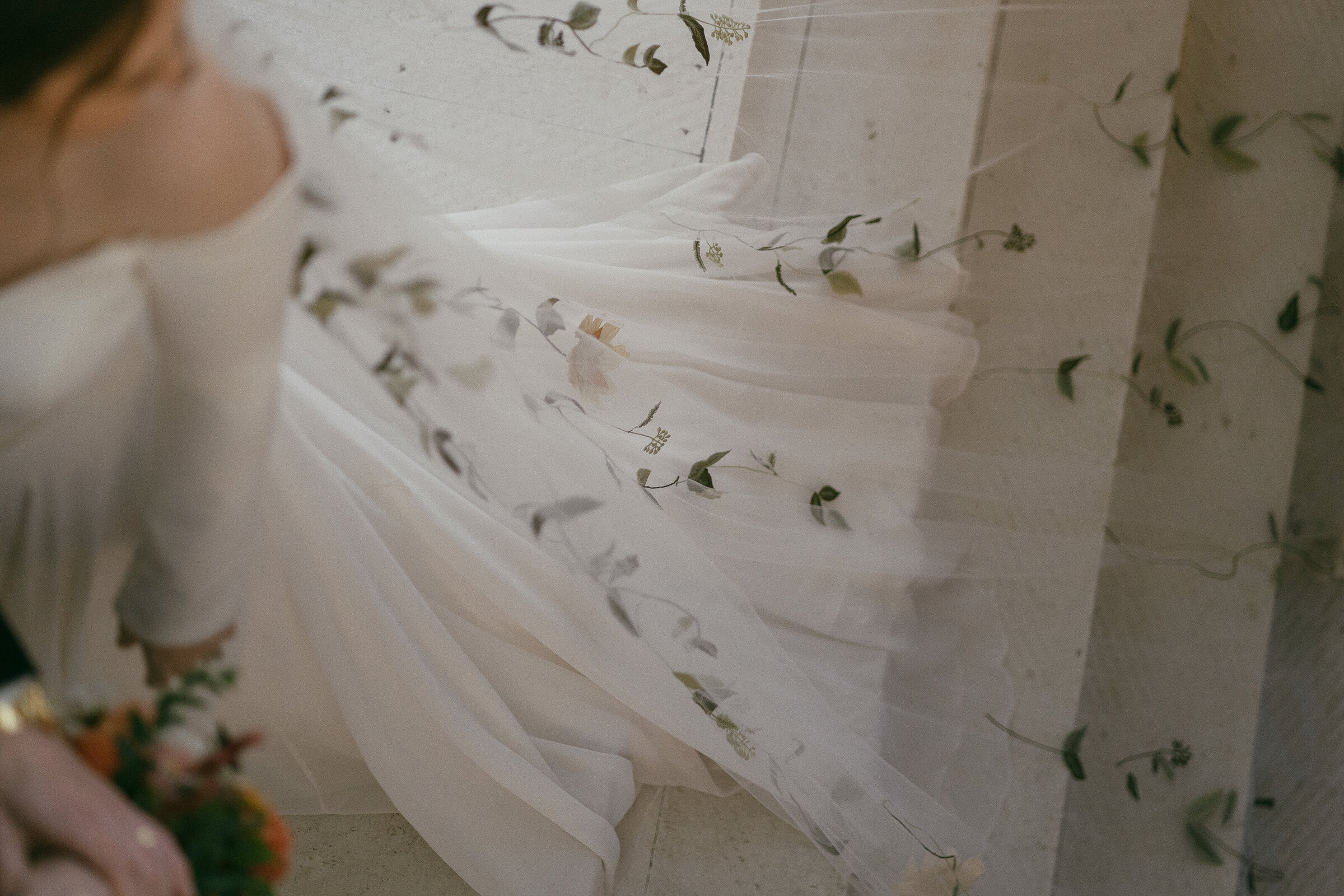 Close-up of a bride's veil with delicate floral embroidery.