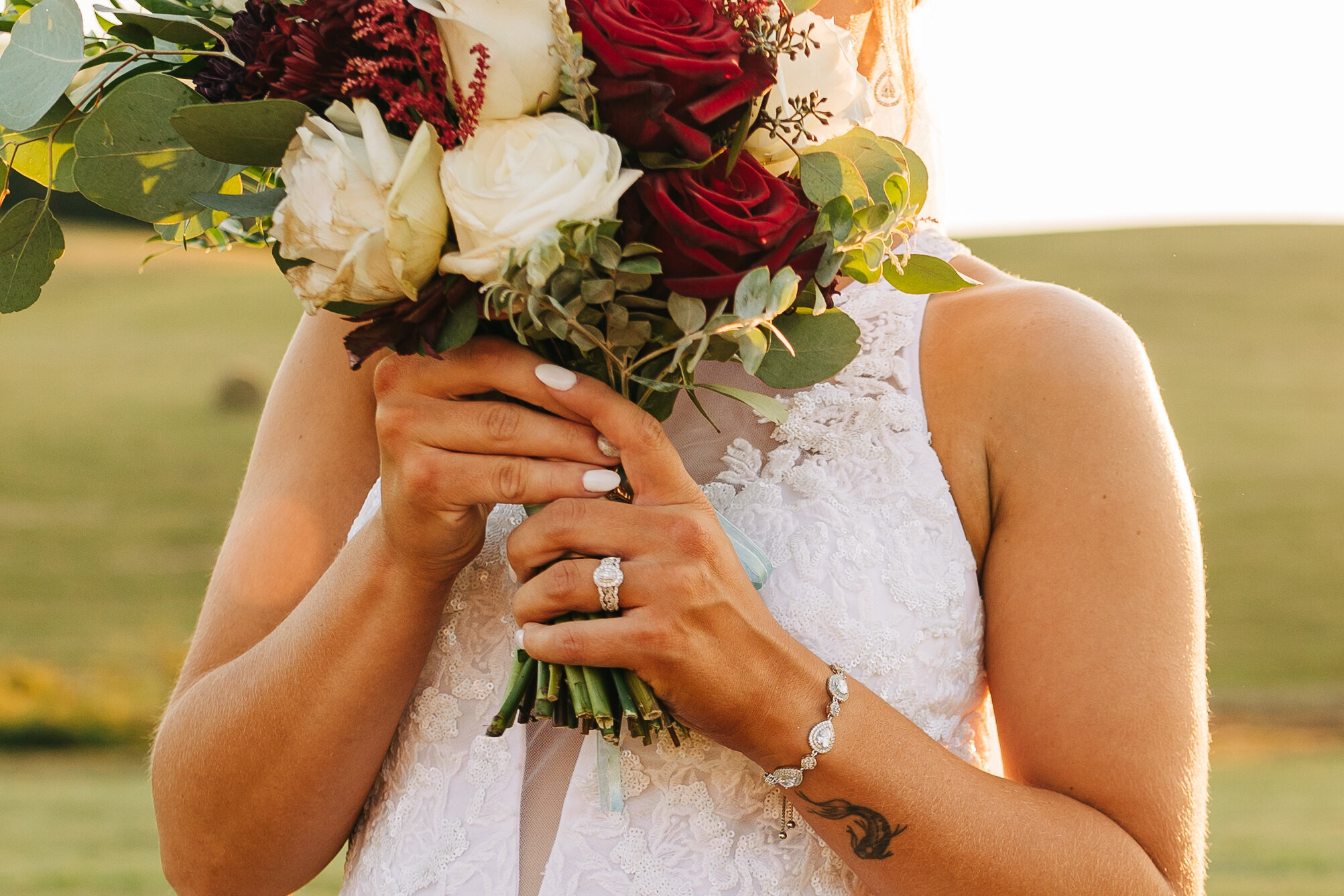 Bride holding her white and red rose bouquet
