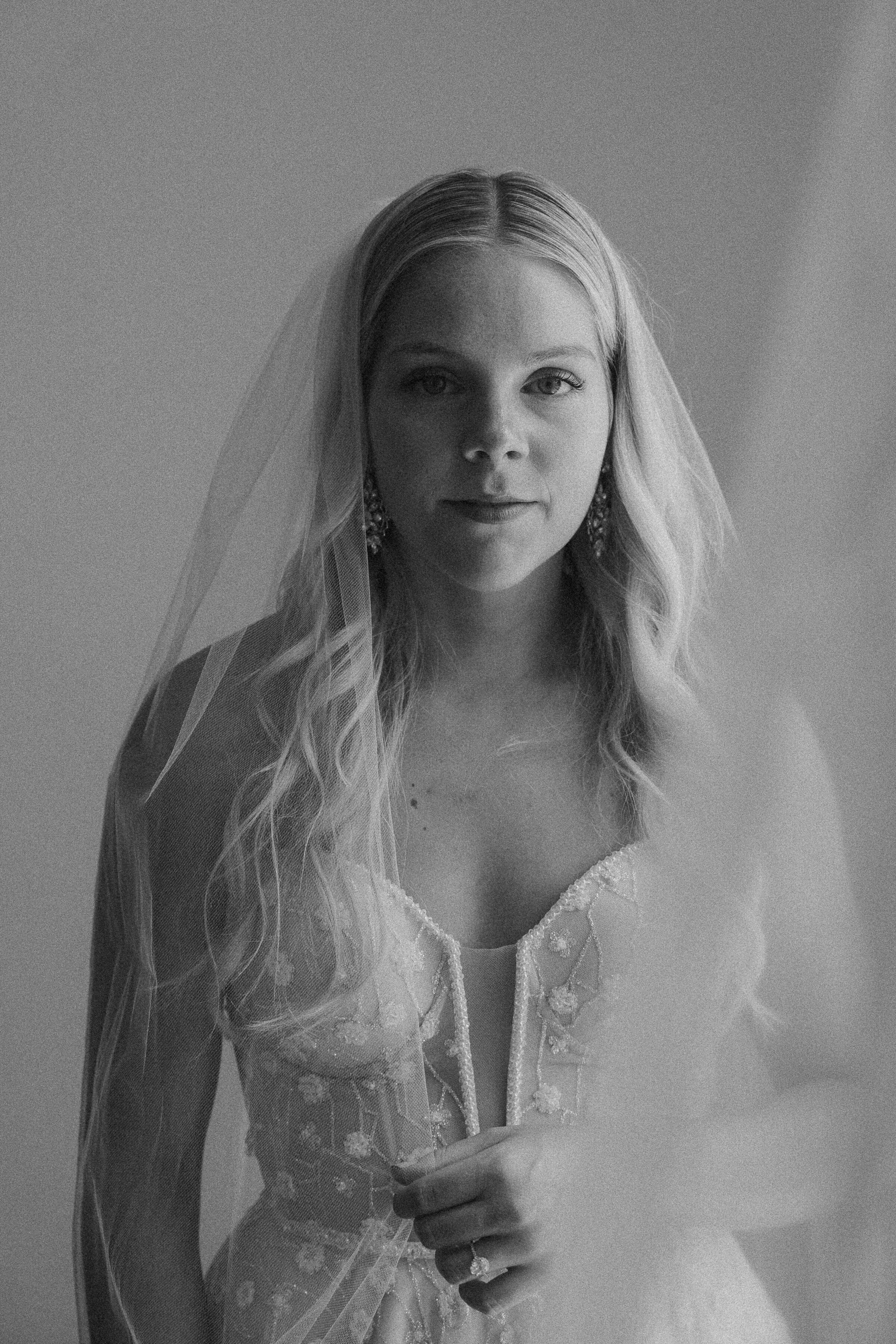 Portrait of a bride in a wedding dress with a veil, black and white photo.