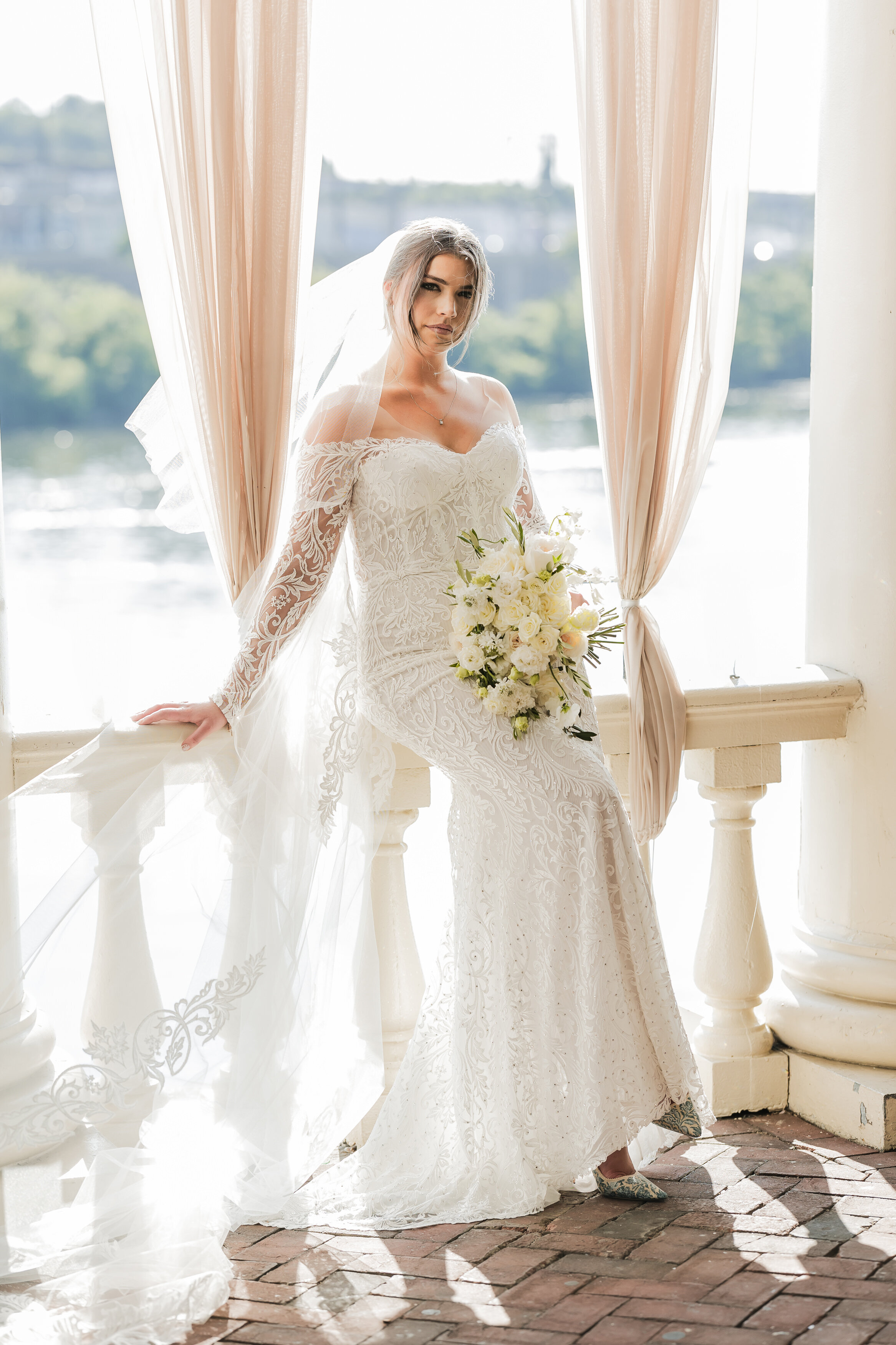 Editorial style portrait of the bride wearing an elegant off shoulder wedding gown at Water Works wedding in Philadelphia