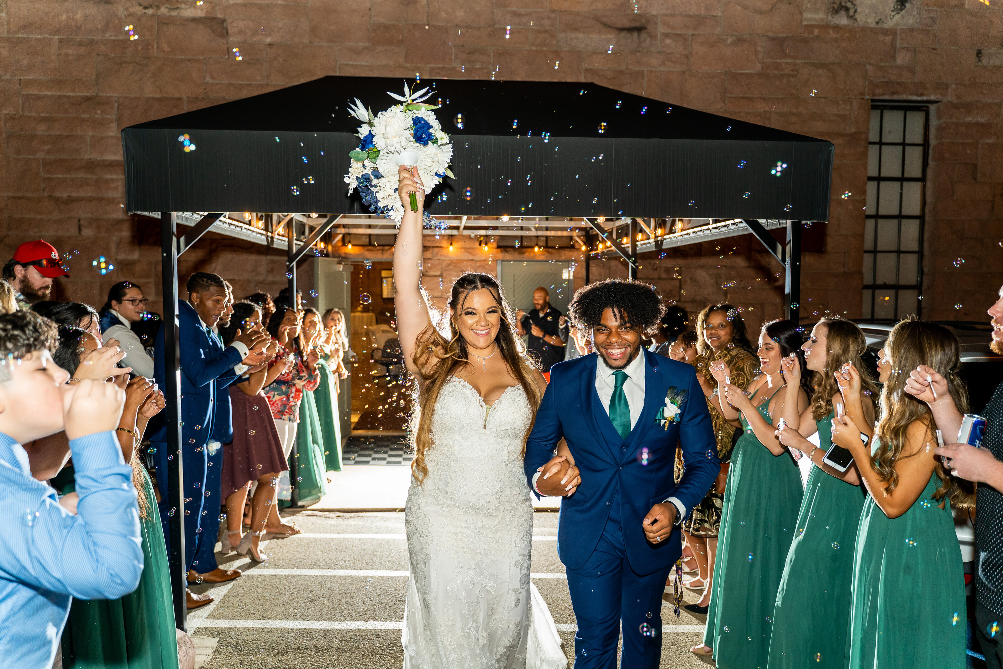 bubble exit bride and groom walking away raising bouquet oklahoma wedding photographer