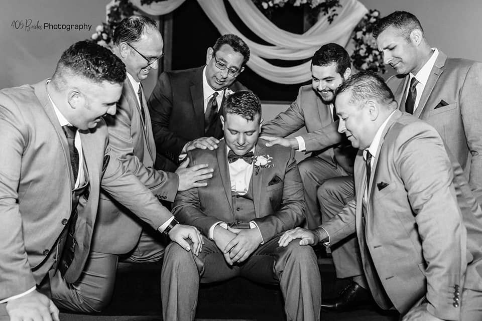 oklahoma grromsmen poses praying over the groom wedding photographer