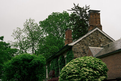 harming stone house with ivy and brick chimney surrounded by lush trees – photographed by wedding photographer Niko Coric – Lumen Clarity Media
