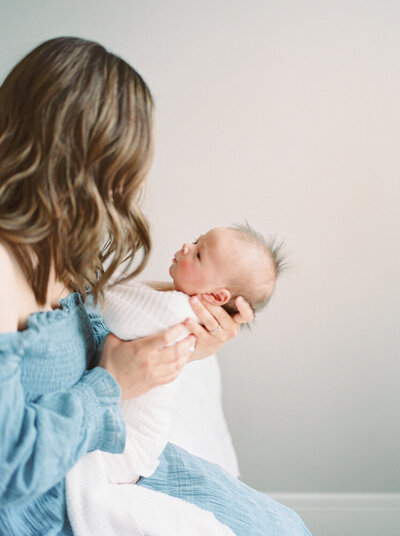 Kahla Kristen, a newborn photographer in Edmonton, holds a newborn baby during one of her newborn sessions