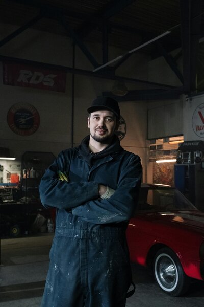 Mechanik v montérkách v autoservisu Audo Viktoria, připravený k práci