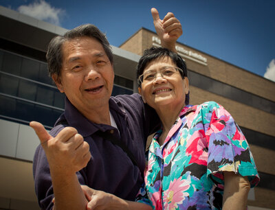 asian mother and father celebrating with thumbs up at the hospital