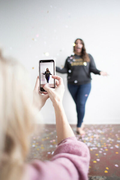 Photo of woman filming a Tiktok video of another woman on her phone
