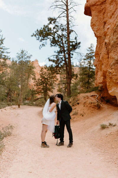 Bride and Groom (both in hiking boots) kissing during their adventurous Utah elopement