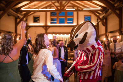mascot with guests dancing inside the barn