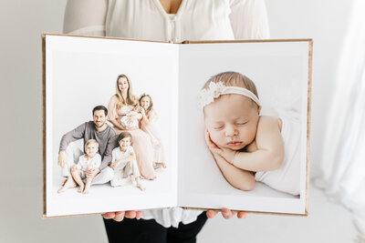 spread of heirloom album featuring family and newborn baby