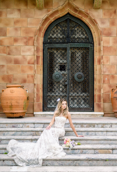 bride sitting on the front steps of wedding venue