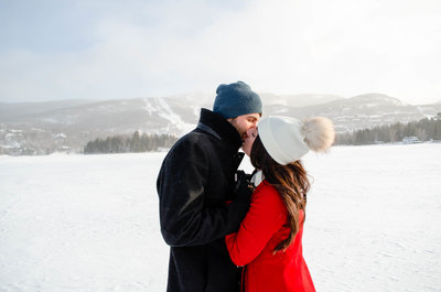 Winter engagement photography session in the snow with mountains behing.