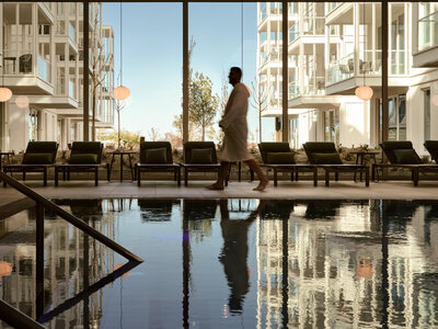 Mann läuft am Pool und Fensterfront des 639 THE VELA SPAS entlang.