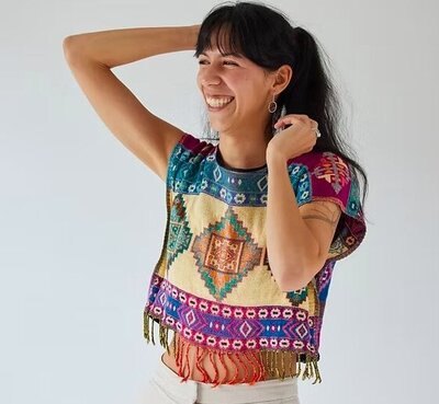 Alexi Bravo smiling joyfully in a colorful woven top, breathwork and holistic healing facilitator based in Puerto Escondido, Mexico.
