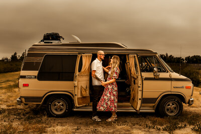Engaged couple infront of camper van