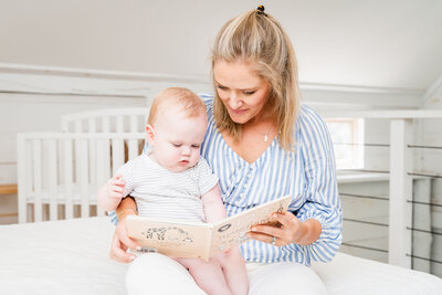 Newborn coach Kristen reading a book to a happy baby