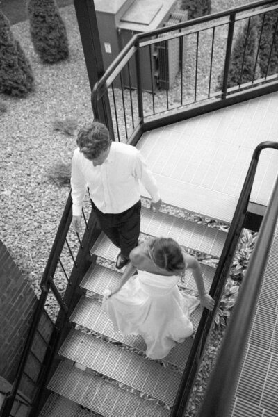 A couples walks down the steps to their reception