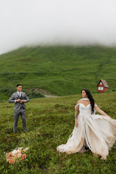 bride and groom standing on black rocks with lake superior in the background and lush green trees