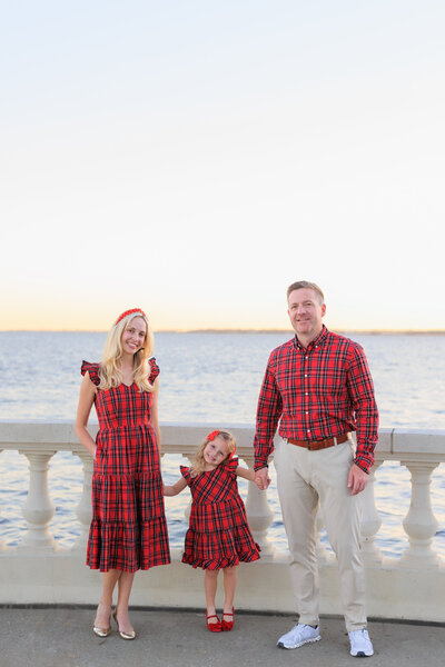 Mom and Dad wearing holiday plaid pose next to the iconic wall of bayshore blvd in Tampa, FL