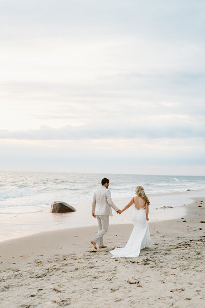 newlyweds walk on beach