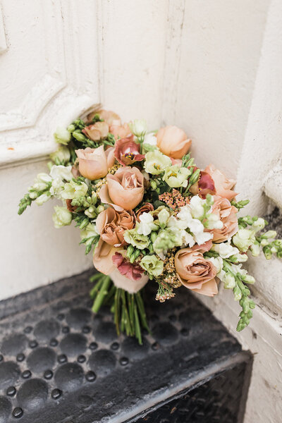 beautiful blush and white bridal bouquet  sitting on a black step
