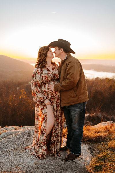 couple kissing on a cliffside at sunset