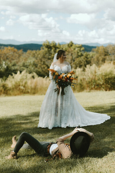 woman photographing bride and groom on a mountain