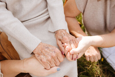 mom, daughter, and grandmother holding hands
