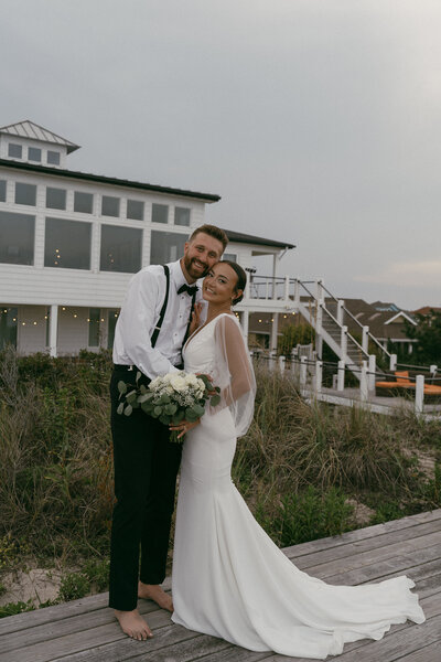 Bride and groom posing on a boardwalk