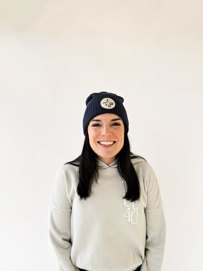 woman smiling wearing navy cropped beanie