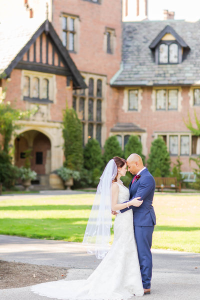 Bride and groom touching foreheads on their fall wedding day at Stan Hywet photographed by akron ohio wedding photographer