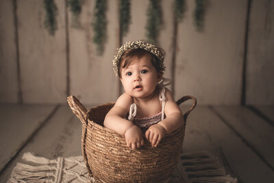 Bébé fille avec Head band fleuri dans un panier osier
