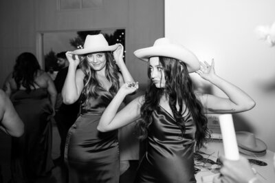 Two girls trying on cowboy hats