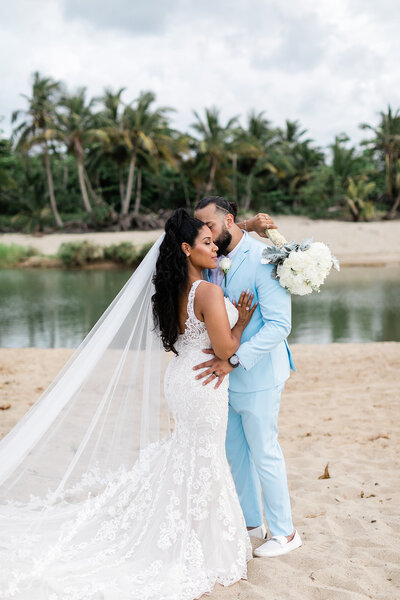 bride-and-groom-holding-each-other-at-the-beach-in-puerto-rico-in-wedding-attire