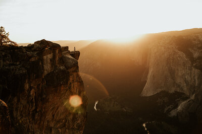 Sunset elopement at Taft Point in Yosemite National Park with couple standing on cliff edge overlooking dramatic mountain valley