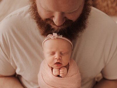 Father holding newborn baby during photography session