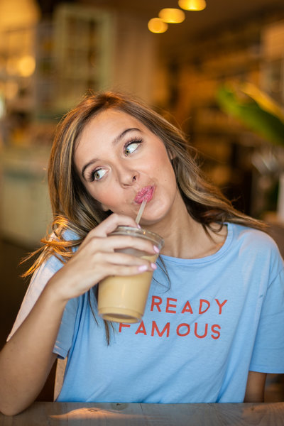 Teen girl sips iced coffee during photography session