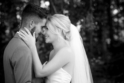 Bride and groom smiling with foreheads together at Dove Meadows by Charlotte wedding photographers DeLong Photography