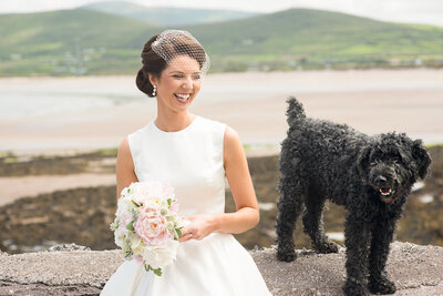 Bride with black hair at beach with black labradoodle