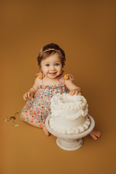 baby girl eats cake during cake smash session in tampa