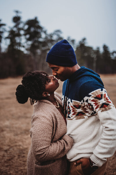 an african american PNW couple about to embrace in a kiss in the rain