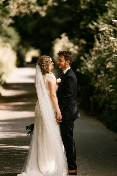 bride-and-groom-looking-into-each-others-eyes-down-country-lane