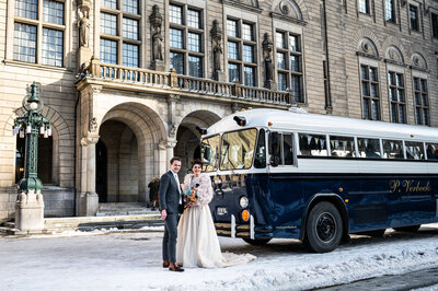 Bruidspaar staat in sneeuw voor bus en lachen