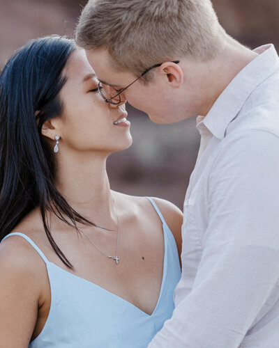 Man and woman go in for a kiss during colorado engagement photo session.