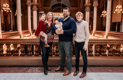 family posing for a photo infront of the Indiana State house
