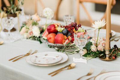 wedding table porcelain plates golden cutlery and fruits in middle