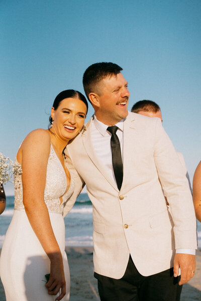 A bride and groom smiling at their wedding at Caves Beach