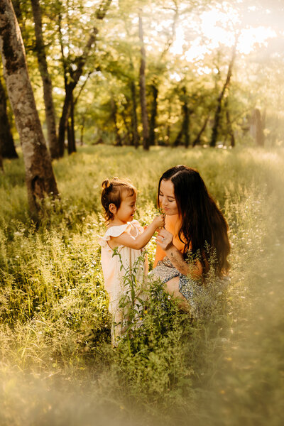 mom and kid standing together in grass